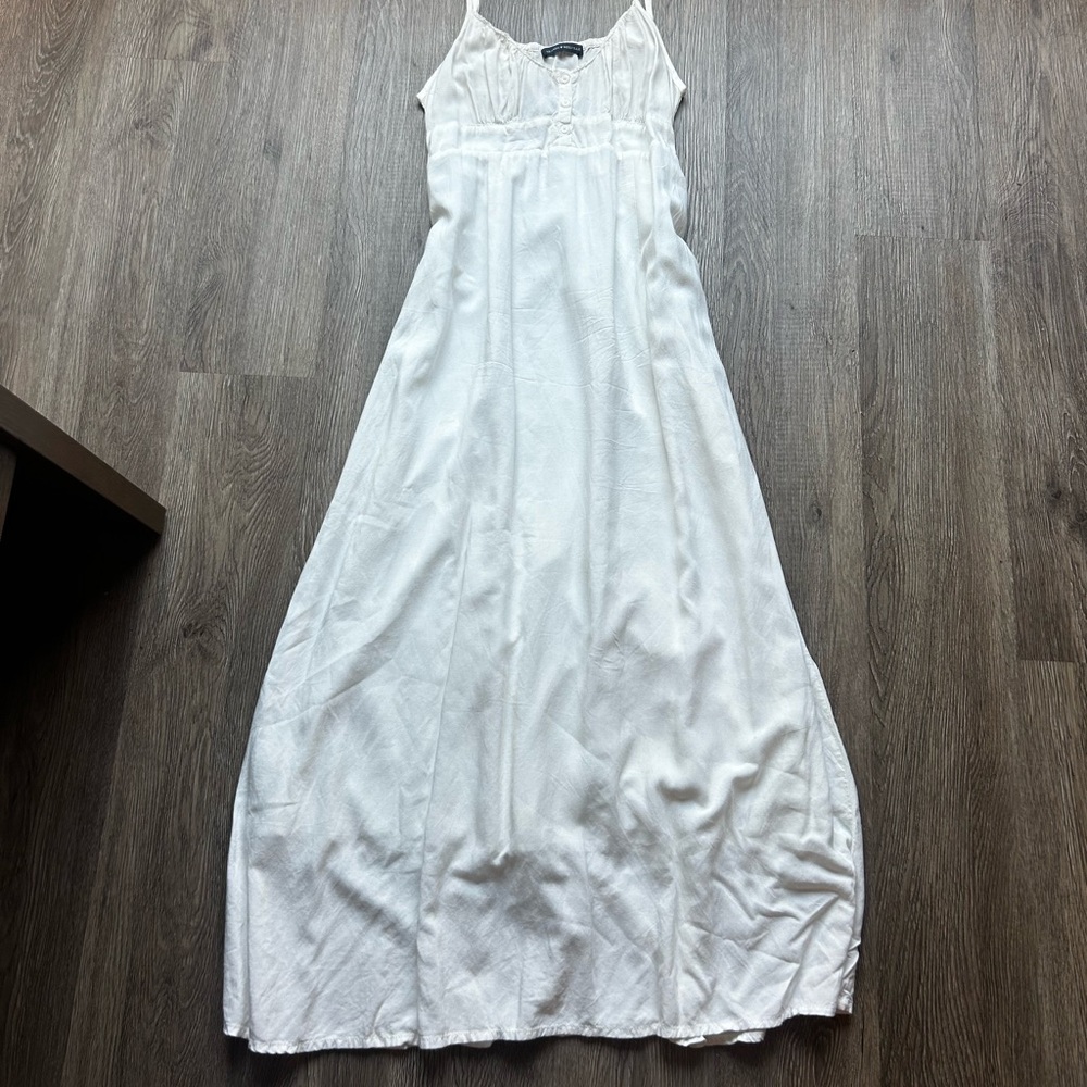 White maxi dress with spaghetti straps and flowy fabric.